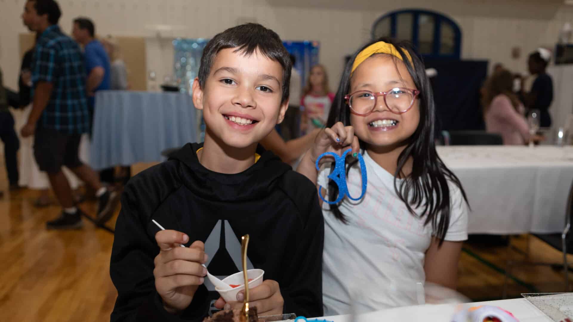 A young girl and boy at a party in the school gym