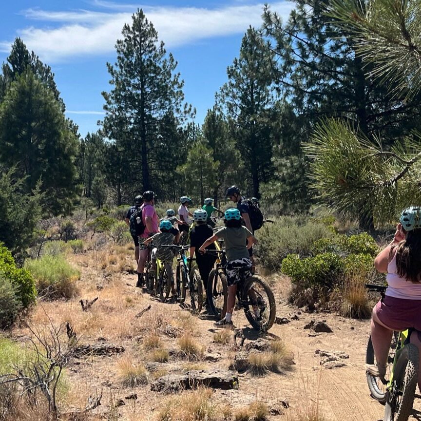 A group of kids riding bikes through a dessert park