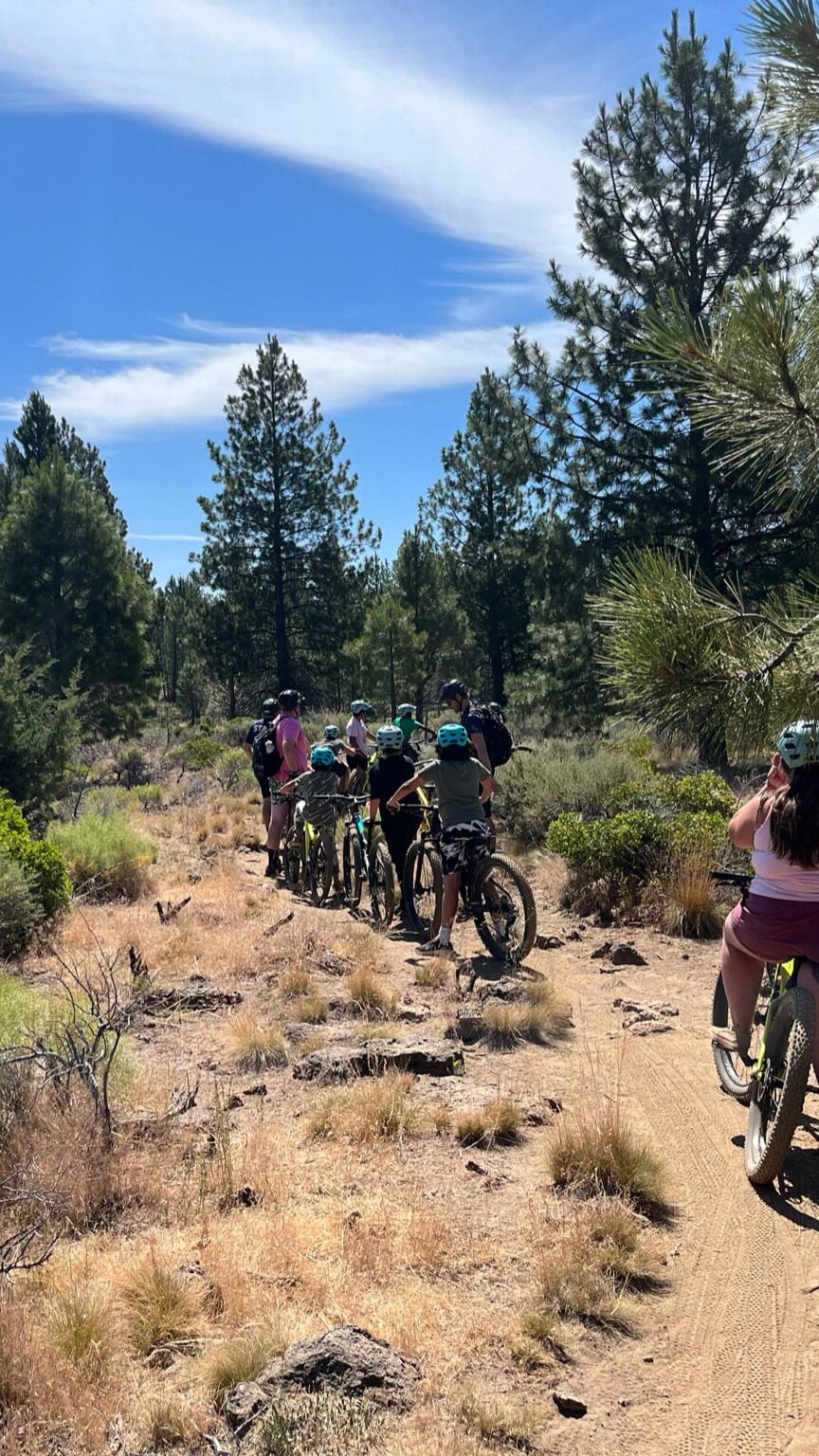 A group of kids riding bikes through a dessert park