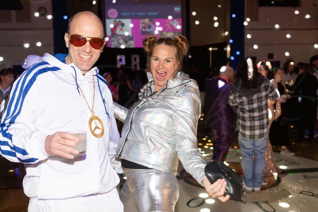 Two people dancing in a gym wearing throwback clothing